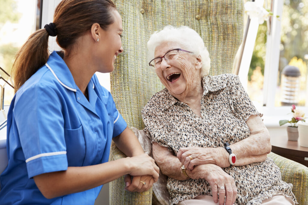 staff and assisted living resident sitting outside laughing